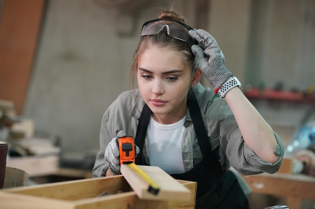 Pequena empresa de uma jovem em fundo de oficina de móveis