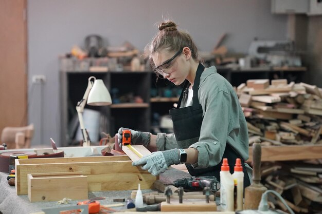 Pequena empresa de uma jovem Uma jovem atraente designer de carpinteiro trabalha na oficina