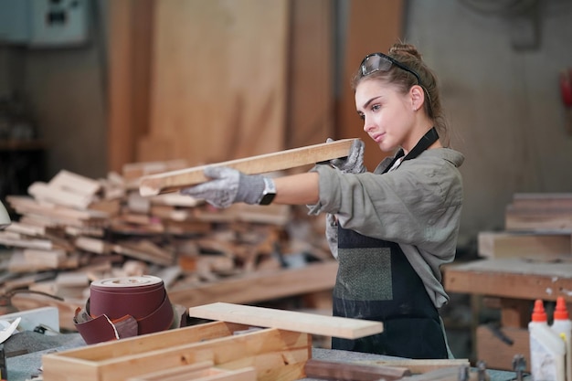 Pequena empresa de uma jovem Uma jovem atraente designer de carpinteiro trabalha na oficina