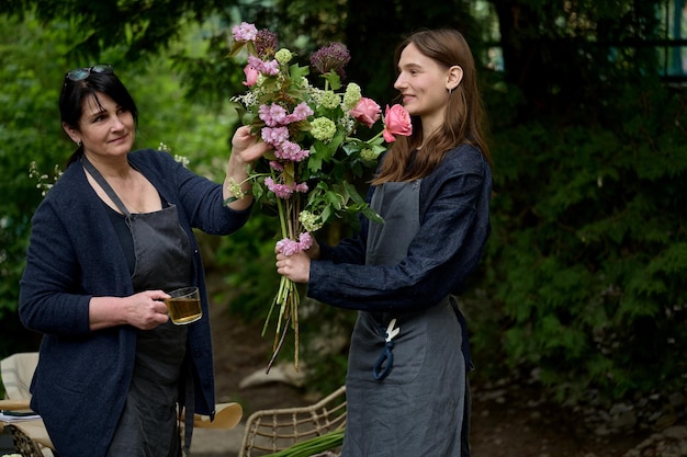 Pequena empresa Family Business, uma jovem e bela florista cria um buquê e sua mãe a ajuda no terraço