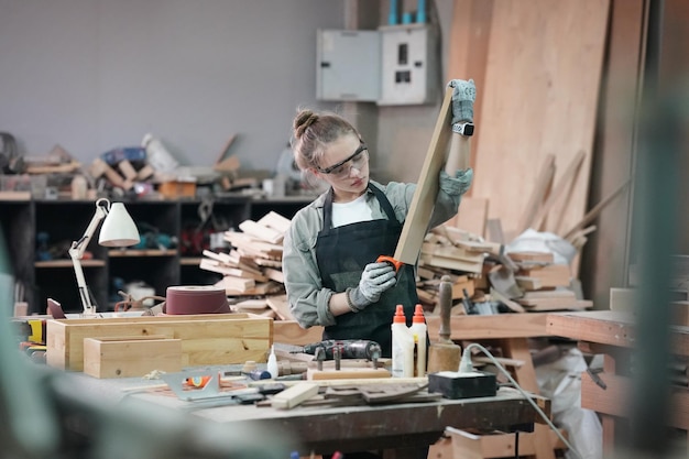 Pequeña empresa de una mujer joven Atractiva joven diseñadora carpintero trabaja en taller