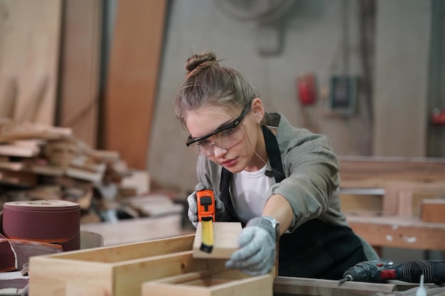 Pequeña empresa de una mujer joven Atractiva joven diseñadora carpintero trabaja en taller