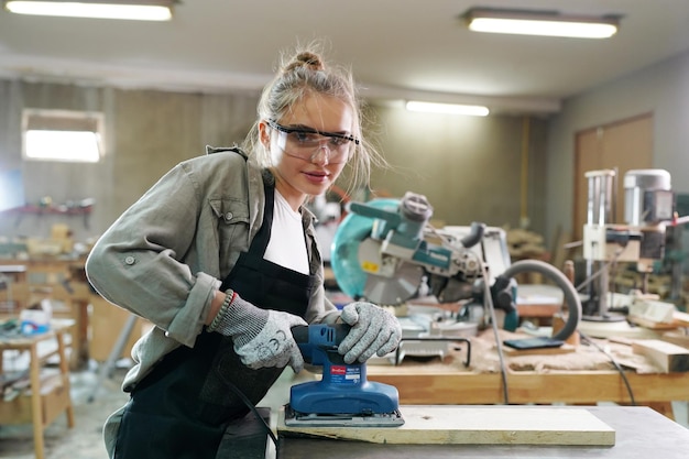 Pequeña empresa de una mujer joven Atractiva joven diseñadora carpintero trabaja en taller