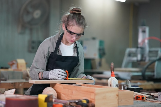 Pequeña empresa de una mujer joven en el fondo del taller de muebles