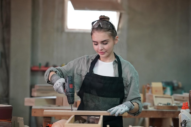 Pequeña empresa de una mujer joven en el fondo del taller de muebles