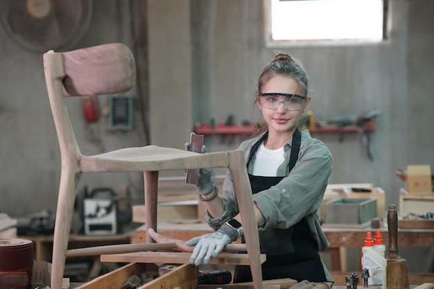 Pequeña empresa de una mujer joven en el fondo del taller de muebles