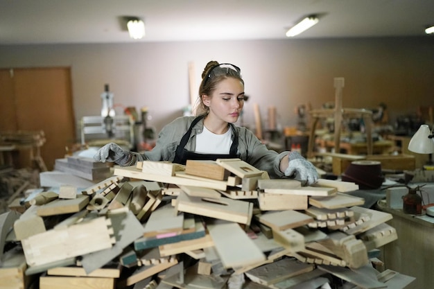 Pequeña empresa de una mujer joven Hermosa joven trabajadora en un taller de muebles midiendo madera