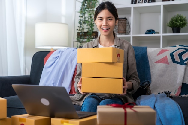 Foto pequeña empresa nueva, entrega de cajas de cartón de mano de mujer para productos para enviar a los clientes.