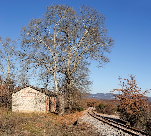 Una pequeña estación de tren en el campo al pie de las montañas en un día soleado otoñal