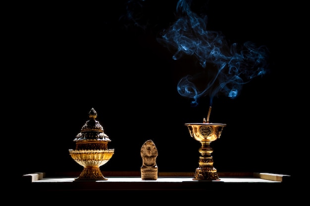 Pequeña estatua de Buda con soporte de incienso con cono encendido.