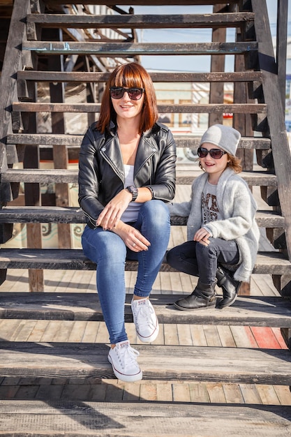 Pequeña fashionista elegante con su madre junto al mar El concepto y la idea son una infancia feliz y divertida