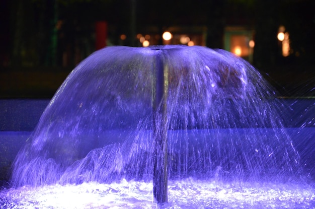 Foto pequeña fuente iluminada por la noche