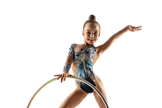 Pequeña gimnasta femenina flexible aislado sobre fondo blanco de estudio