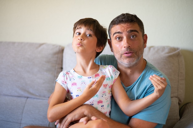 Pequeña hija linda haciendo maquillaje a su padre