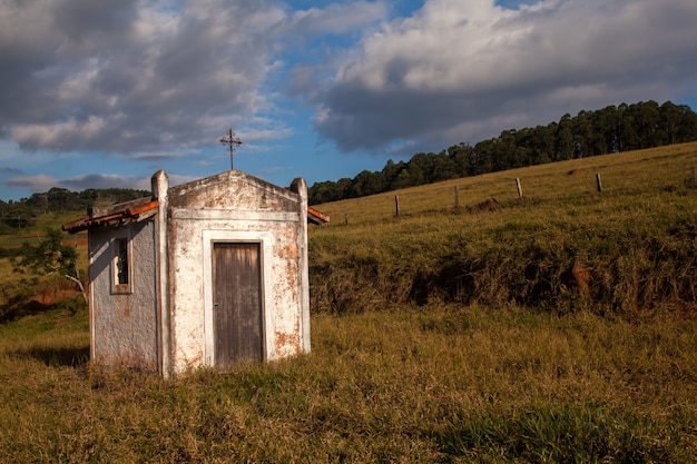 Pequeña iglesia blanca vieja en el campo en un día de cielo azul