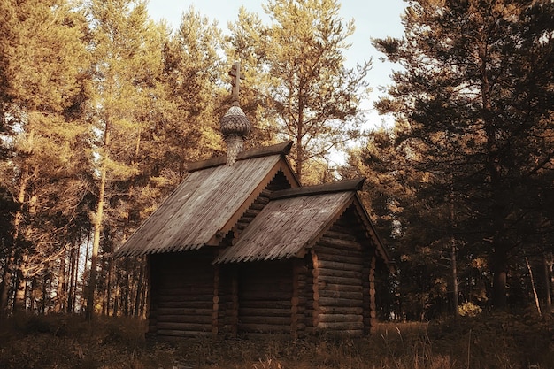 Pequeña iglesia de madera en el bosque, paisaje de verano, concepto de fe ortodoxa nativa