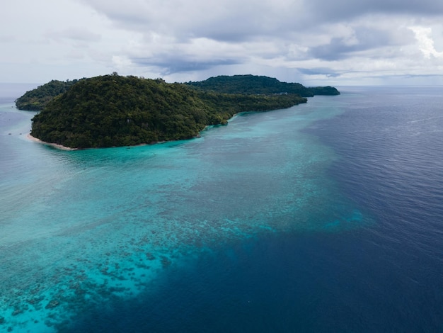 Una pequeña isla en medio de un cuerpo de agua con algunas islas al fondo.