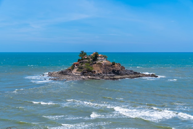 Una pequeña isla en el océano con una casa en ella.