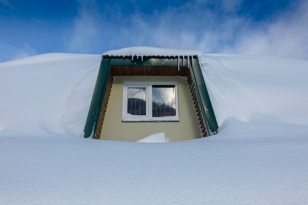 Pequena janela da cabana da montanha coberta com neve branca fresca, conto de fadas de inverno branco