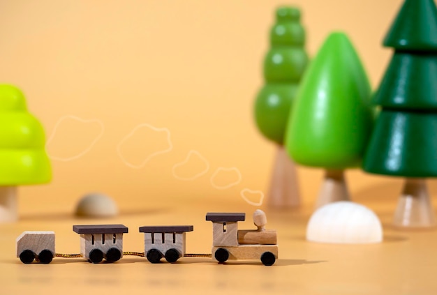 Foto una pequeña locomotora de madera en el fondo de árboles de madera concepto de viaje juguetes de madera ecológicos