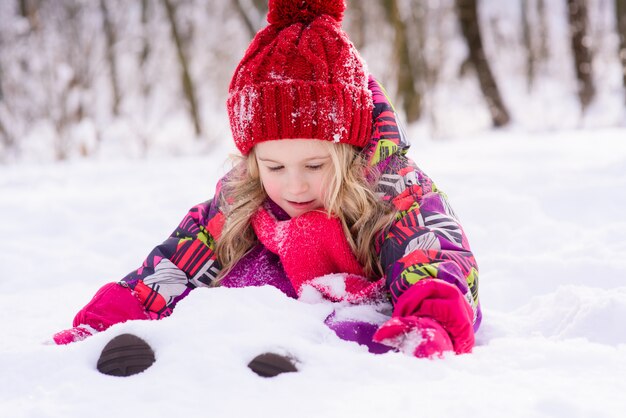 Pequena menina bonito enterrar na neve