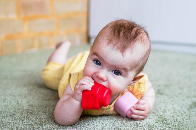 Foto pequena menina caucasiana brincando com um construtor de plástico macio em casa