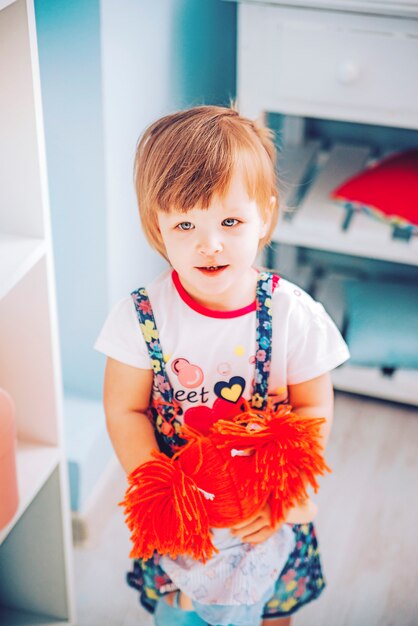 Pequena menina com a boneca de brinquedo sorrindo