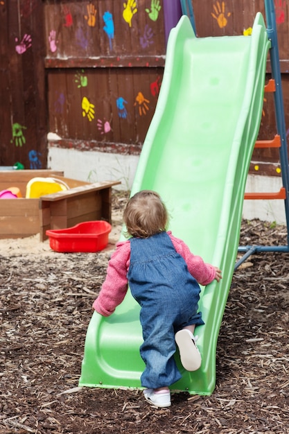 Pequena menina se divertindo com uma calha