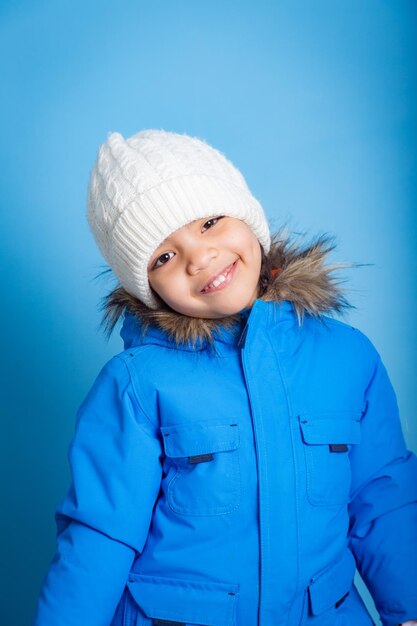 pequeña modelo asiática sonriendo con ropa de invierno preparada para esquiar