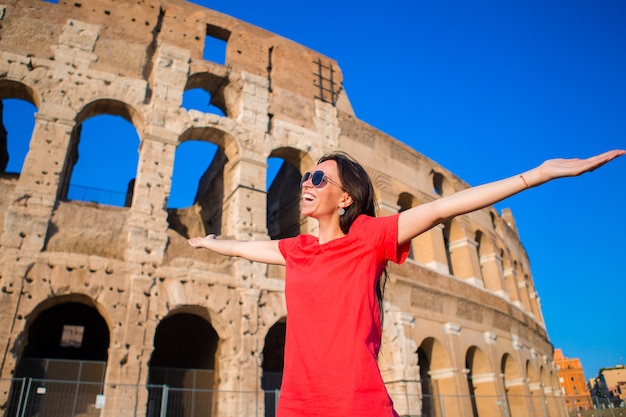 Pequeña muchacha activa adorable con el mapa delante de Colosseum en Roma, Italia.