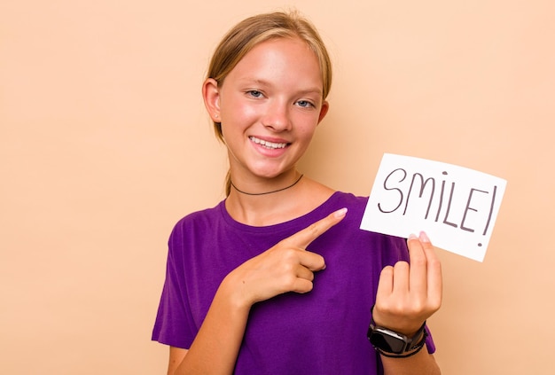 Pequena mulher caucasiana segurando um cartaz de sorriso isolado em fundo bege