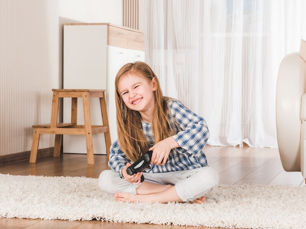 Pequeña niña alegremente sosteniendo el joystick