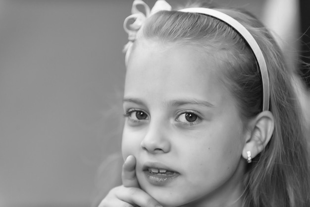 Pequeña niña con cara adorable guiñando un ojo al aire libre