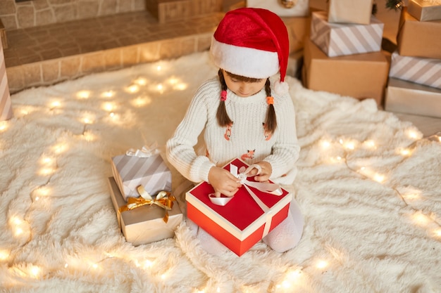 Pequeña niña caucásica con sombrero de santa