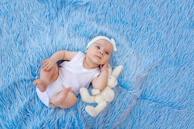 Pequeña niña divertida sobre un fondo azul.