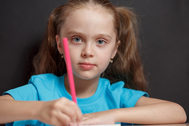 Pequeña niña estudiando en la escuela