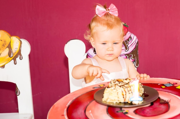 Pequeña niña feliz celebrando el primer cumpleaños Kid y su primer pastel en la fiesta Infancia