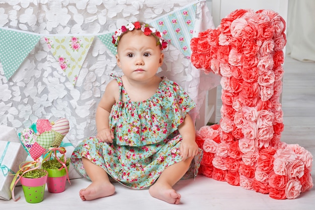 Pequeña niña pequeña feliz que celebra el primer cumpleaños.