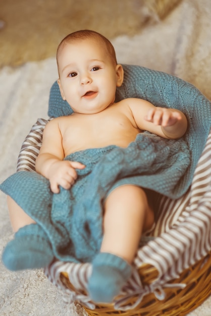 Pequeña niña sonriente muy linda acostada en la canasta