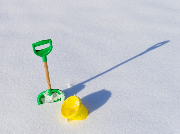 Pequena pá e balde na neve profunda