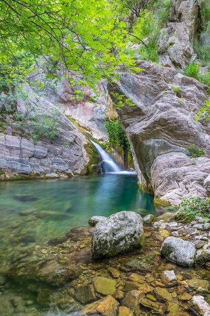 Una pequeña y pintoresca cascada en una acogedora laguna de montaña.