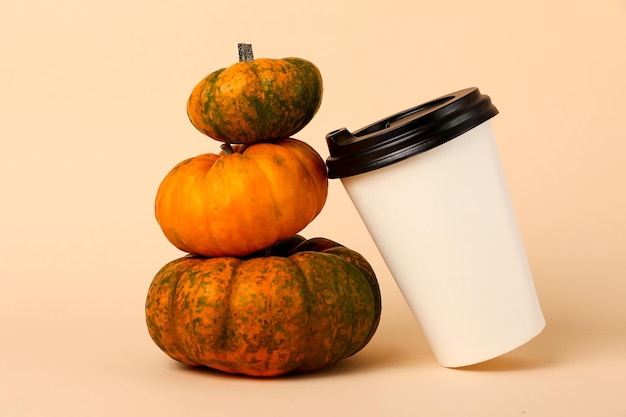 Pequeña pirámide de calabazas y taza de café cerca de itSpicy latte concept