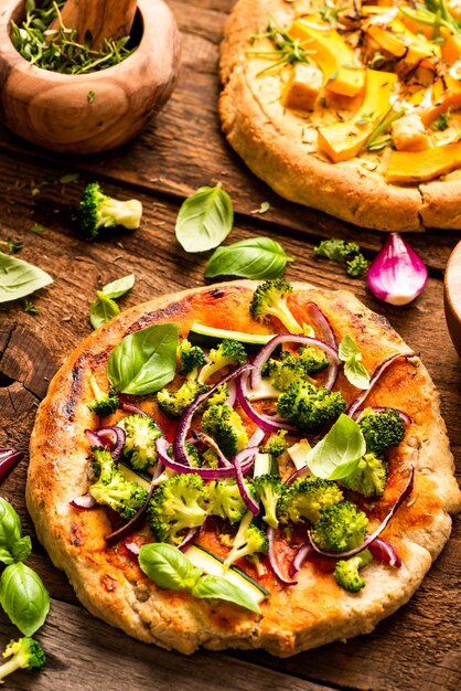 Foto pequeña pizza vegetariana casera en una mesa rústica de madera vista de arriba hacia abajo