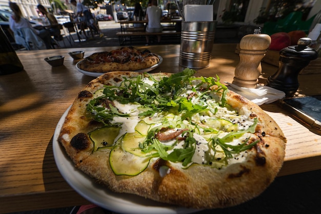 Pequeña pizza vegetariana en una mesa en un café de la calle