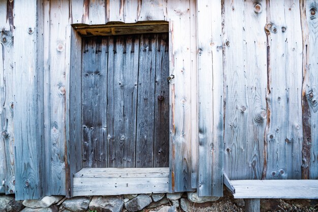 Pequena porta fechada em uma bela parede de madeira de uma casa antiga com padrões incomuns