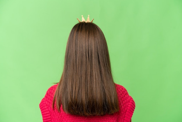 Pequeña princesa con corona sobre fondo clave de croma aislado en posición trasera