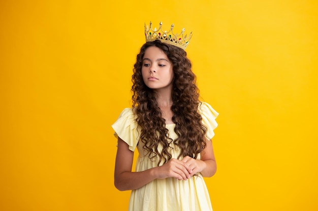 Pequena rainha usando coroa dourada Princesa adolescente segurando a tiara da coroa Festa de formatura conceito de infância