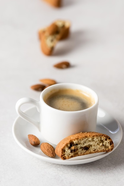 Pequeña taza de café espresso y sabroso biscotti fondo gris vertical