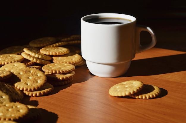 Pequeña taza de café y galleta salada.