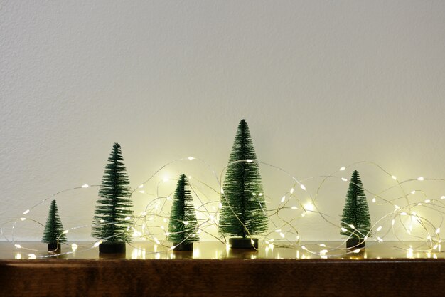 Pequenas árvores de natal com guirlandas de luzes